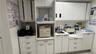Extensive built-in white cabinetry, integrated sink, and white countertops