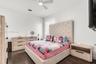 Dark wood-finish flooring, white walls, recessed window, and ceiling fan with integrated lighting