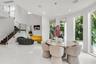 Curved architectural walls, high ceilings, large format tile flooring, wood-finish staircase with metal railings, and full-height windows