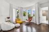 Curved wall with multiple windows, dark wood-finish flooring, recessed lighting, and a white interior door