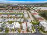 Aerial perspective of a multi-story residential property with a flat roof, situated in a community featuring varied architectural styles and establish