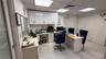 Recessed ceiling with integrated lighting, white wall-mounted cabinetry, built-in desk with integrated storage, white tile flooring, and louvered clos