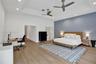 Tray ceiling with recessed lighting, two ceiling fans, wood-finish flooring, and a distinct accent wall