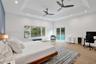 Tray ceiling with recessed lighting and two ceiling fans, wood-finish flooring, large window with water and greenery, and sliding glass door to exteri