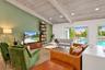 Vaulted wood-plank ceiling with exposed beams, recessed lighting, expansive sliding glass doors, wood-finish flooring, and a built-in shelving unit
