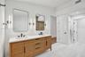 Double vanity with a light wood-finish cabinet, white countertop, and rectangular undermount sinks
