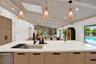 Kitchen island featuring a single basin sink, matte black faucet, and light-toned cabinetry with dark hardware