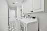 White shaker cabinetry, recessed lighting, and patterned floor tiling