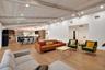 Vaulted ceiling with exposed beams, recessed lighting, wood-finish flooring, built-in kitchen cabinetry, and a large kitchen island with seating