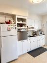 White cabinetry with brushed nickel hardware, built-in wall oven, and flush-mount ceiling light fixture
