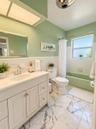 White vanity with integrated sink, chrome faucet, and storage cabinetry