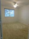 Practicability of a full bedroom one bath downstairs, ceiling fan, dual bi-fold panel doors, and double French doors opening to tile flooring
