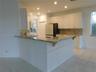 Kitchen featuring white cabinetry, granite countertops, and recessed lighting