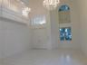Double-door entry, tiled flooring in all social areas, soaring ceilings, arch-top window, and two crystal chandeliers