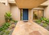 Flagstone walkway with river rock landscaping beds, featuring a deep blue entry door, and a dedicated entry light fixture
