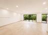Spacious room featuring light-toned tiled flooring, recessed lighting, and expansive glass sliding doors