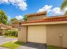 Stucco exterior with a tiled roof, integrated garage, and private balcony