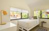 Wood-finish flooring, white walls, and multiple windows with roller shades