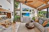 Living Room w/ Expansive Impact Windows & Beautiful Tropical Landscaped Views