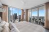 Floor-to-ceiling windows, sliding glass door to a private balcony, ceiling fan, and recessed lighting