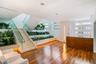Wood-finish flooring, staircase with glass railing, integrated planters, built-in reception desk, and horizontal window banks