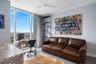 Expansive floor-to-ceiling windows, gray tone walls, a ceiling fan, and gray tile flooring
