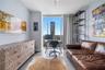 Floor-to-ceiling windows, light gray wall color, built-in shelving, and light wood-finish flooring