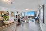 Expansive window wall with cityscape, sleek tile flooring, and integrated ceiling lighting