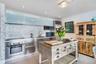 Stainless steel appliances, mosaic tile backsplash, recessed lighting, and a unique wood-finish kitchen island