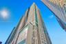 Modern high-rise architectural design with extensive window placements, multiple balconies, and a distinct structural facade