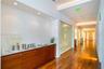Wood-finish flooring throughout, recessed lighting, built-in wooden cabinetry with a light-colored countertop, and frosted glass panels