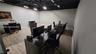 Spacious room featuring wood-finish flooring, white walls, and a black exposed ceiling with track lighting