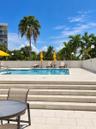 Outdoor swimming pool with integrated steps, surrounded by a stone paver deck and tropical landscaping
