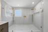 Oversized walk-in shower with largeporcelain tile and dual rainfall heads
