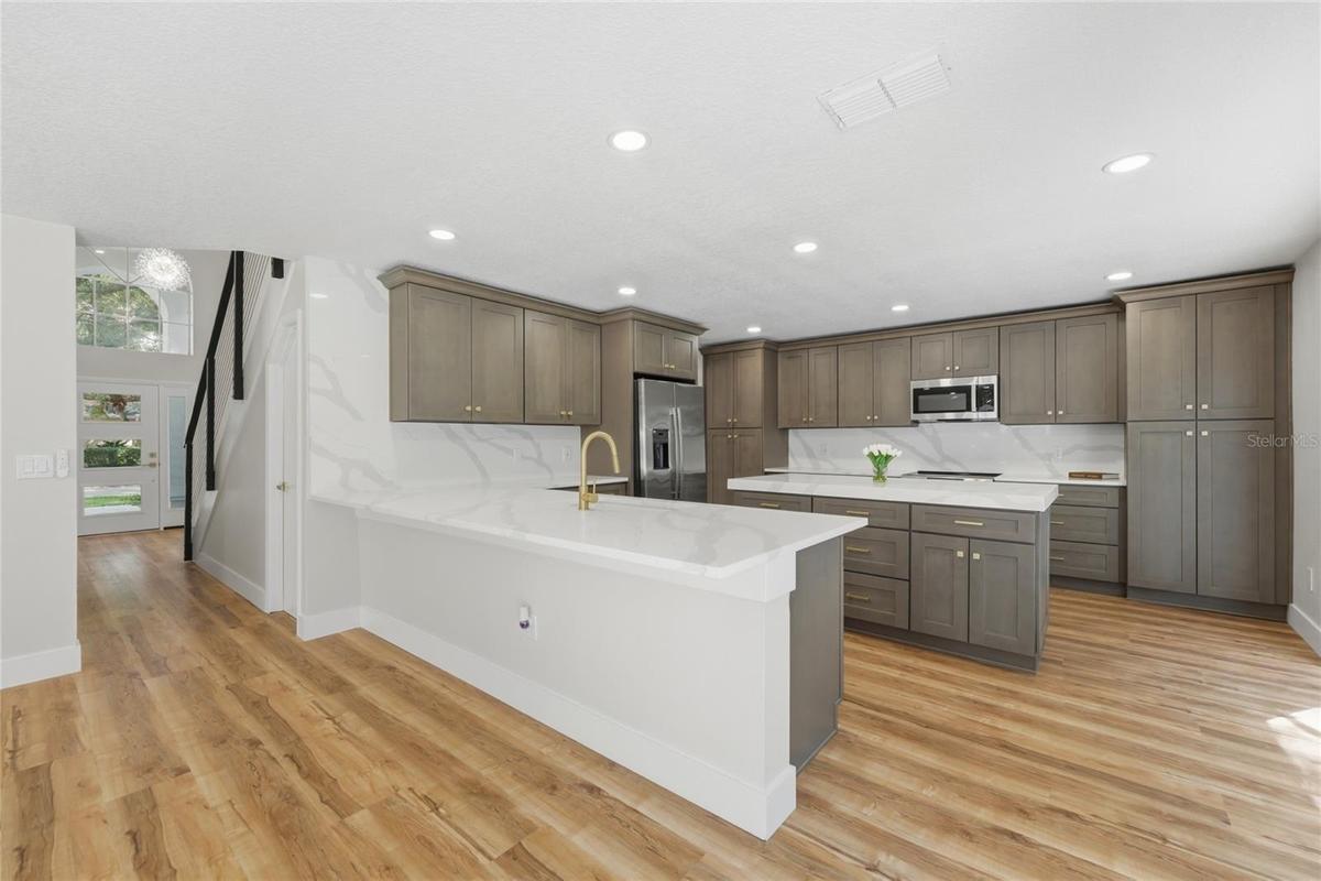 This chef’s dream kitchen offers elegant stone countertops, a deep undermount sink, and ample storage