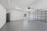 Spacious garage with generous parking space, windows for natural light, and a dedicated exit door