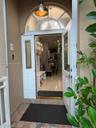 Entryway featuring an arched transom window, a white paneled door with decorative glass inserts, and a bronze-finish pendant light fixture