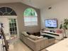 Vaulted ceilings, arched windows, sliding glass door, tiled flooring, and a ceiling fan