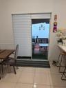 Sliding glass door opening to an outdoor area with a railing and string lights
