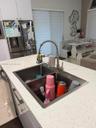 Kitchen island featuring a dual stainless steel sink and a high-arch pull-down faucet