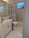Bathroom featuring a built-in vanity with a white countertop, undermount sink, and white cabinetry