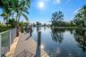 Waterfront property featuring a composite deck, aluminum railing, and tropical landscaping
