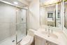 Vanity with an integrated sink, polished chrome faucet, and gold-toned light fixture