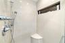 Shower with polished chrome fixtures, integrated niche with mosaic tile accent, a built-in corner bench, and large format wall tiling