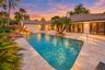 Rectangular swimming pool surrounded by stone paving