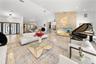 Vaulted ceiling, recessed lighting, stone accent wall, double entry doors, and polished flooring