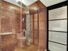 Walk-in shower with full glass enclosure, floor-to-ceiling mosaic tile, multi-function shower panel, and recessed lighting