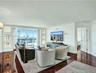 Rich wood-finish flooring throughout, integrated wall niches, and sliding glass doors opening to an outdoor living space