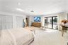 Wall-to-wall carpeting, recessed lighting, louvered closet doors, and direct outdoor access through glass sliding doors