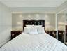 Recessed lighting, crown molding, wood-finish flooring, mirrored closet doors, and a built-in headboard